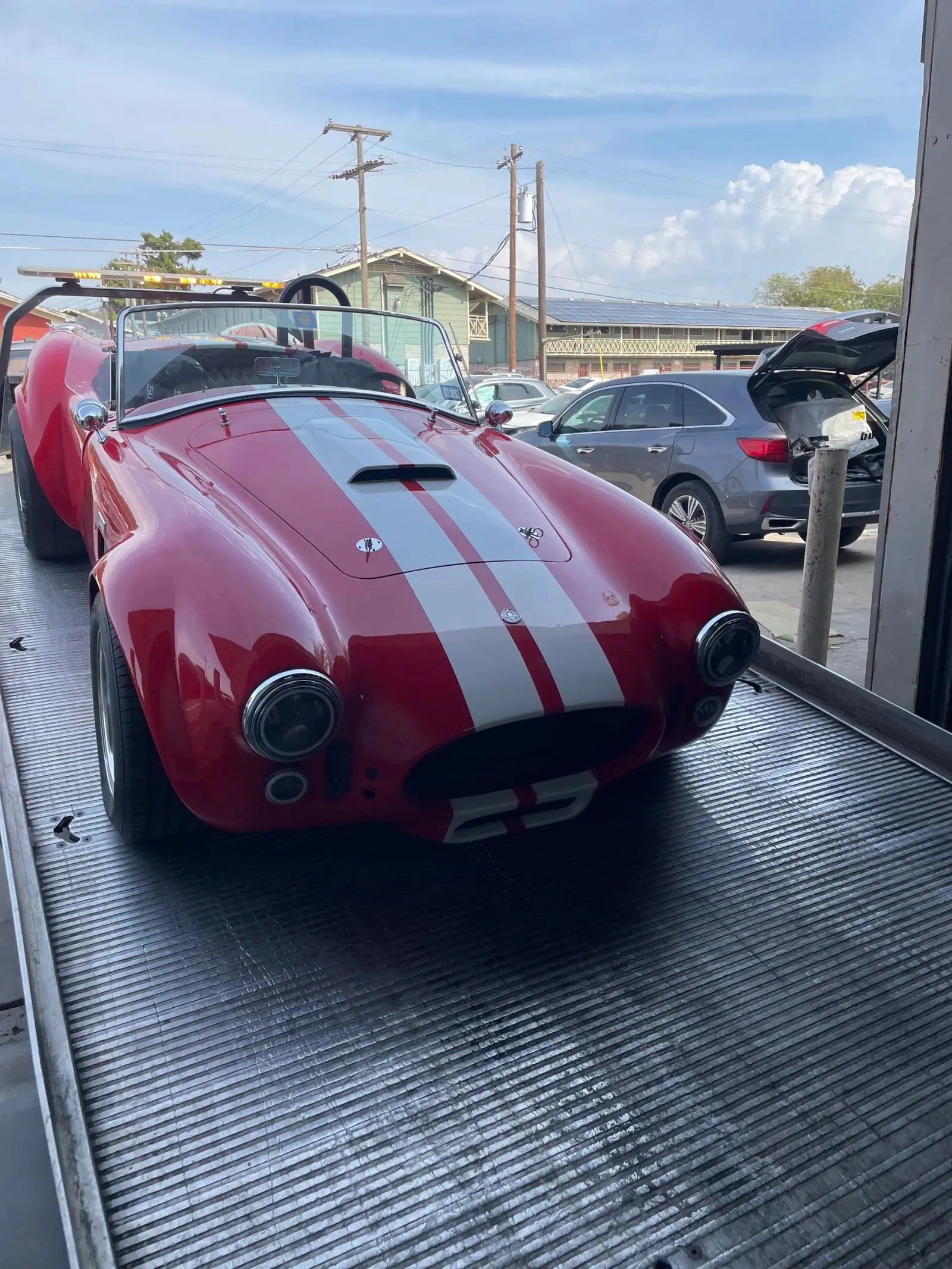 Red Shelby Cobra on a tow truck bed
