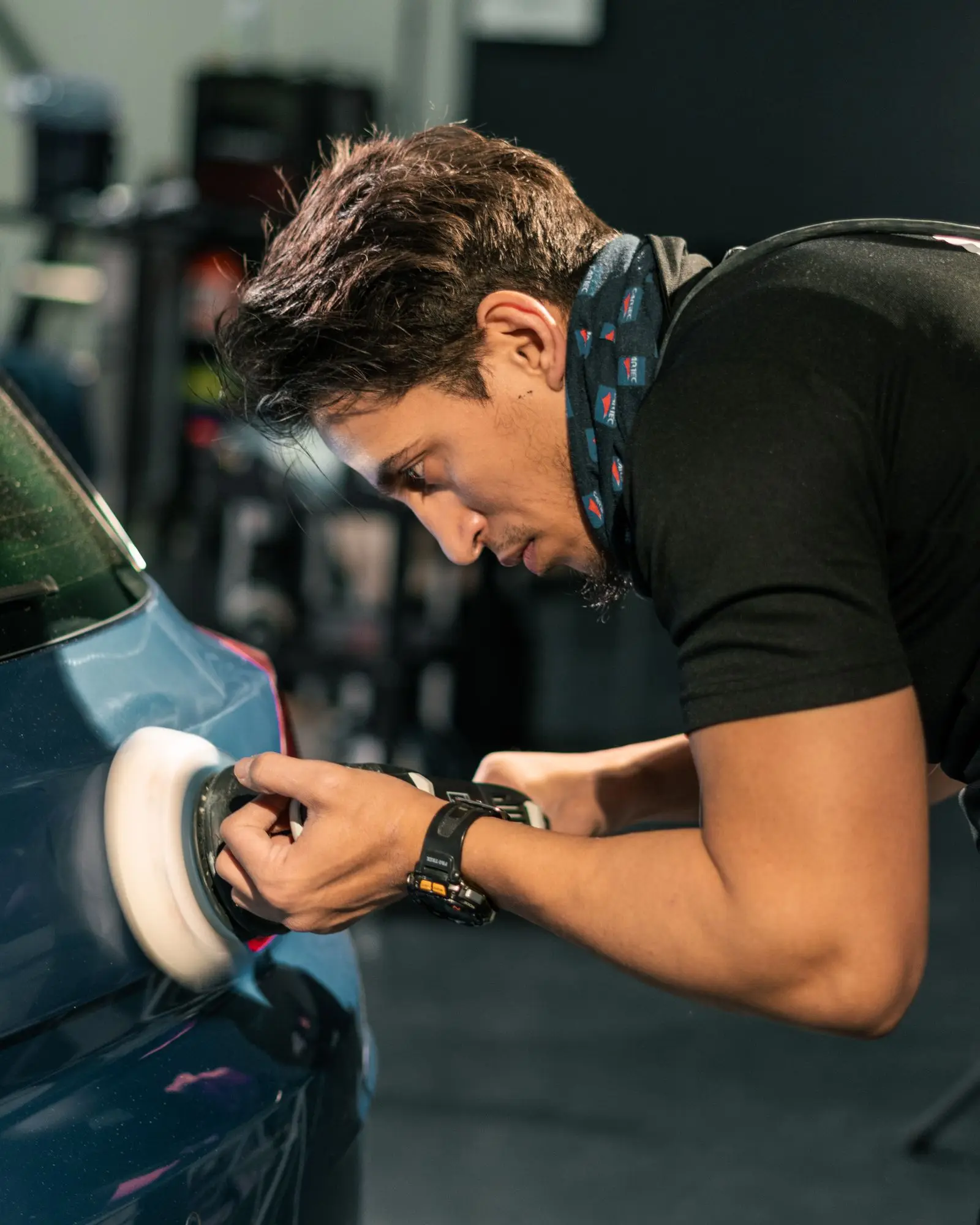 Detailer machine-buffing a car's paint