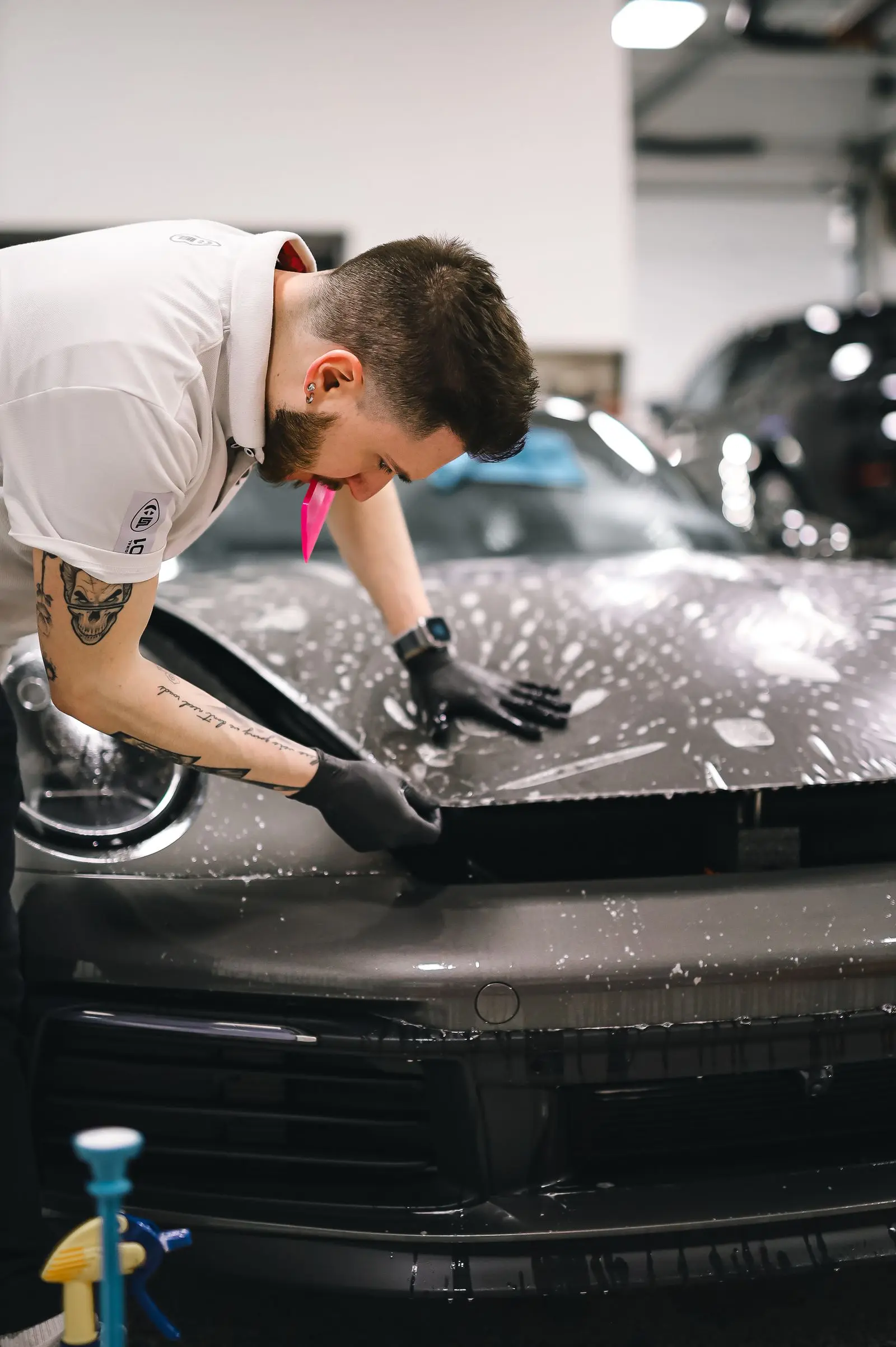 Installer squeegeeing paint protection film onto a hood