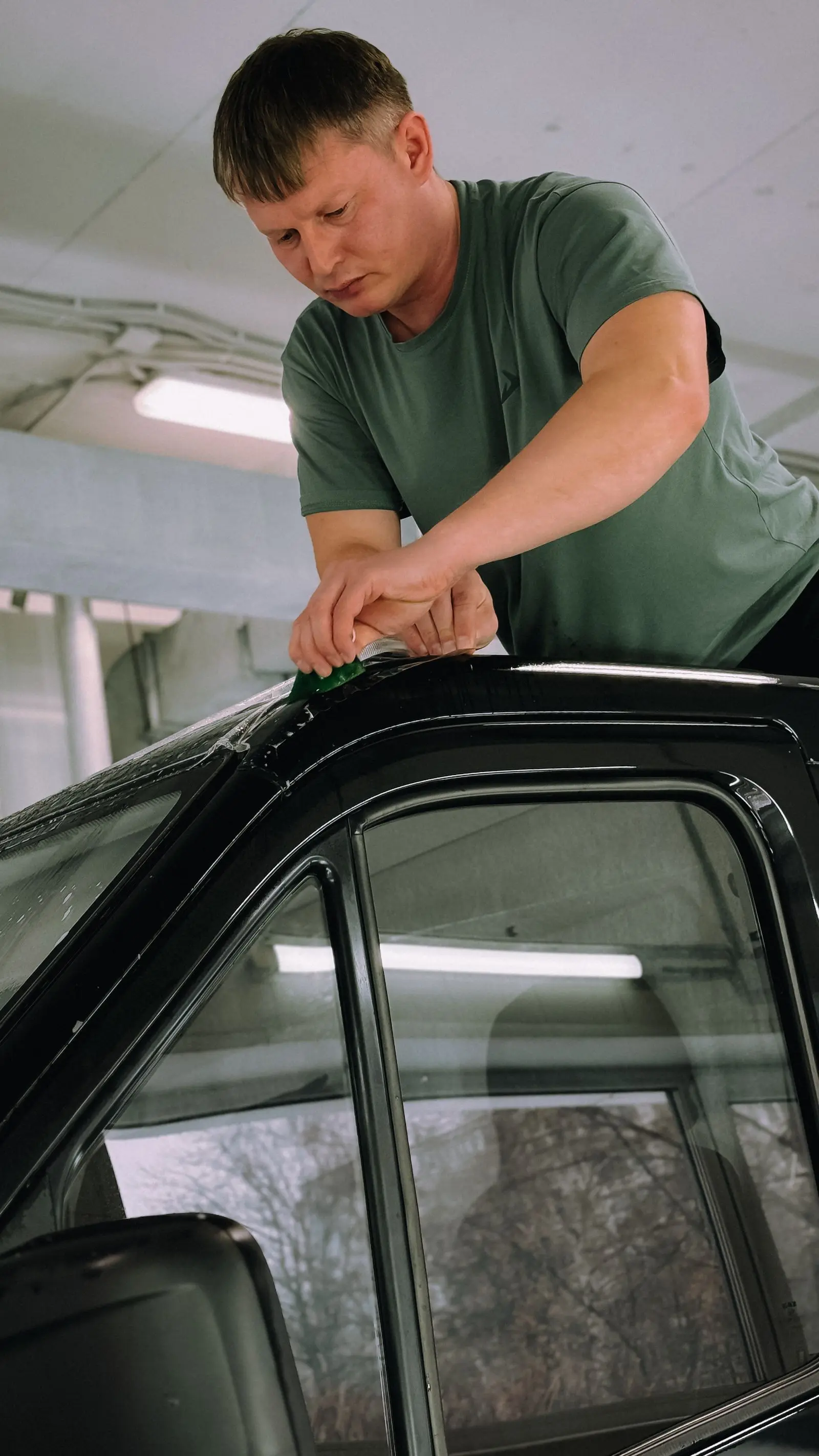 Installer fitting window tint film on a car door